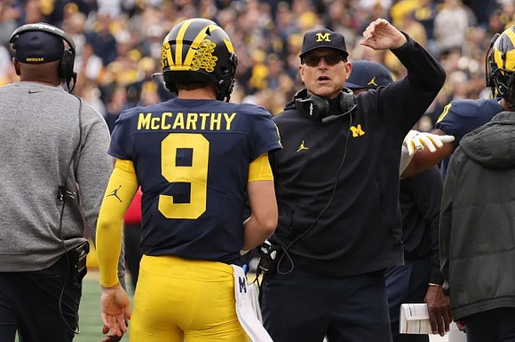 J.J. McCarthy (9) and Jim Harbaugh