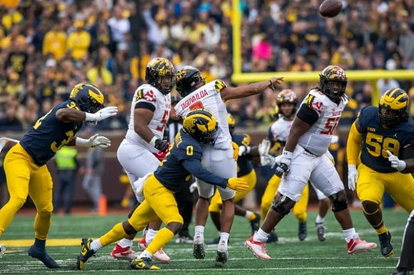 Jaylen Harrell (32), Mike Sainristil (0), and Mazi Smith (58)