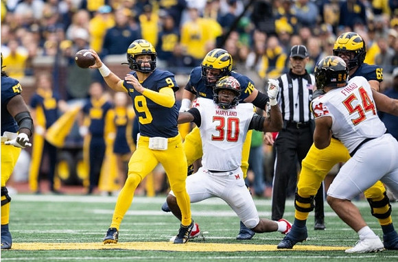 Trente Jones (53), J.J. McCarthy (9), Ryan Hayes (76), and Zak Zinter (65)