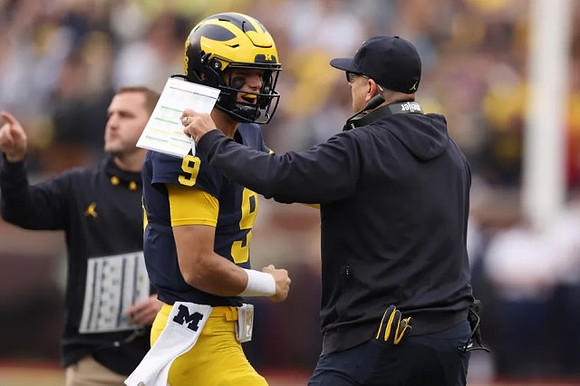 J.J. McCarthy (9) and Jim Harbaugh