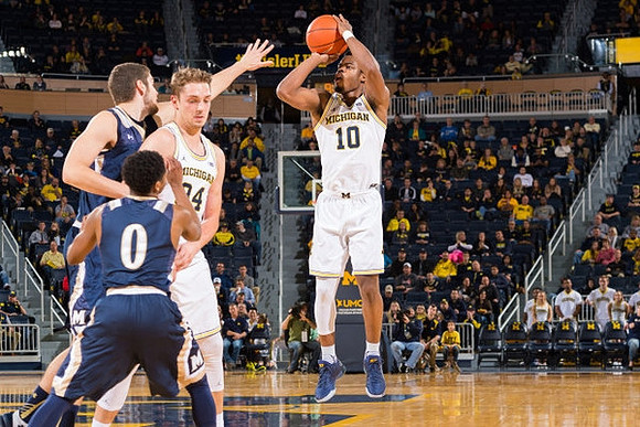 Mark Donnal (34) and Derrick Walton Jr. (10)
