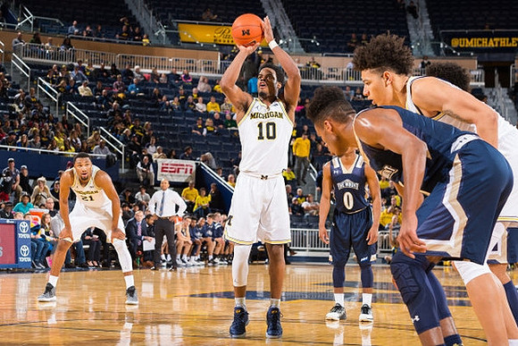 Zak Irvin (21), Derrick Walton Jr. (10), and D.J. Wilson (5)