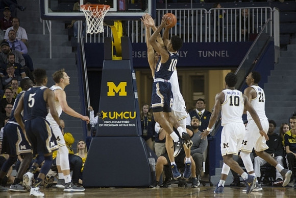 Mark Donnal (34), D.J. Wilson (5), Derrick Walton Jr. (10), and Zak Irvin (21)
