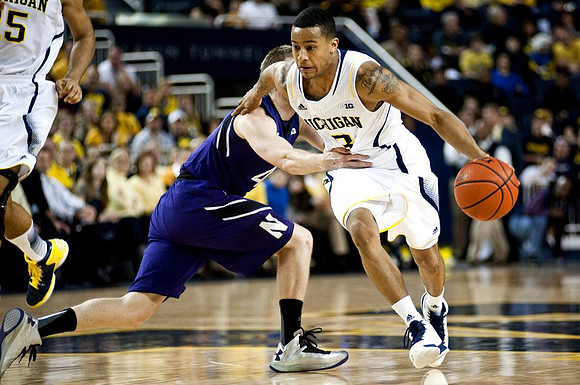 Trey Burke (3) and Jon Horford (15)