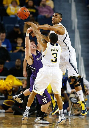 Trey Burke (3) and Jon Horford (15)