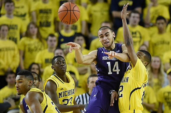 Zak Irvin (21), Caris LeVert (23), and Muhammad-Ali Abdur-Rahkman (12)