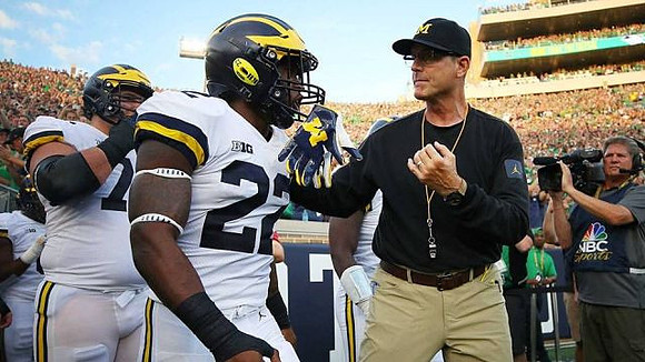 Karan Higdon (22) and Jim Harbaugh