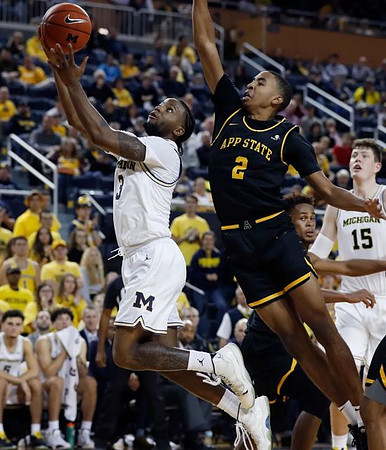 Zavier Simpson (3) and Jon Teske (15)