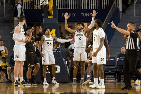 Jon Teske (15), Eli Brooks (55), Isaiah Livers (2), and Zavier Simpson (3)