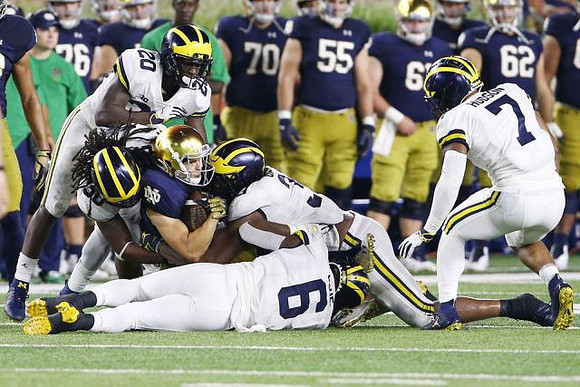 Brad Hawkins (20), Devin Gil (36), Josh Uche (6), Rashan Gary (3), and Khaleke Hudson (7)