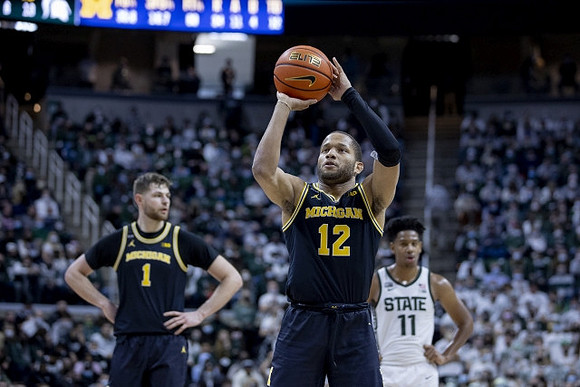 Hunter Dickinson (1) and DeVante' Jones (12)