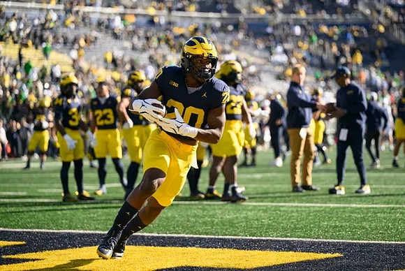 Kalel Mullings (20) and Michigan Team