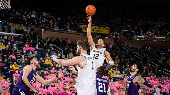 Hunter Dickinson (1) and DeVante' Jones (12)