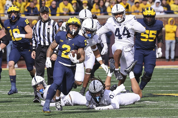 Colston Loveland (18), Blake Corum (2), and Olusegun Oluwatimi (55)
