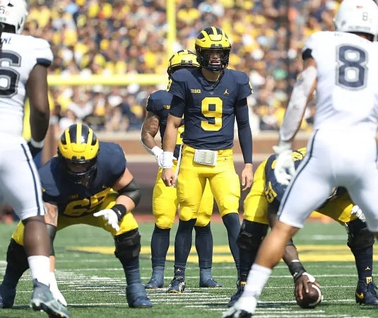 Zak Zinter (65), Olusegun Oluwatimi (55), J.J. McCarthy (9), and Blake Corum (2)