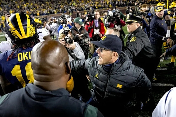 Eyabi Anoma Okie (18), Michigan State Head Coach Mel Tucker, and Jim Harbaugh