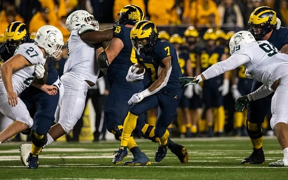 Zak Zinter (65) and Donovan Edwards (7)