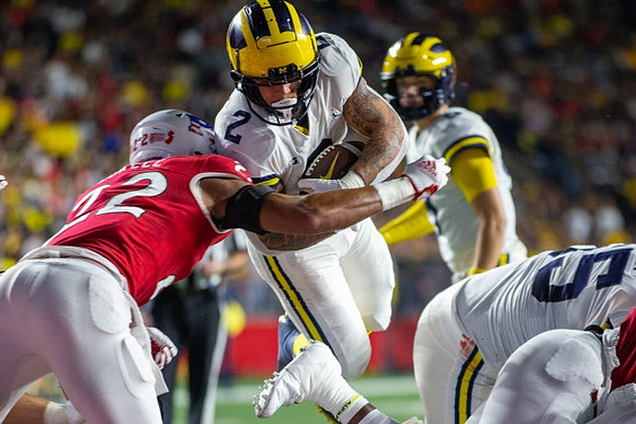 Blake Corum (2), J.J. McCarthy (9), and Olusegun Oluwatimi (55)