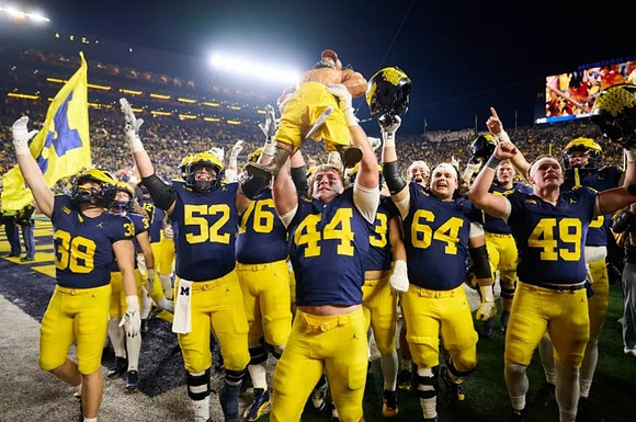 Max Bredeson (44), Paul Bunyan Trophy, and Michigan Team