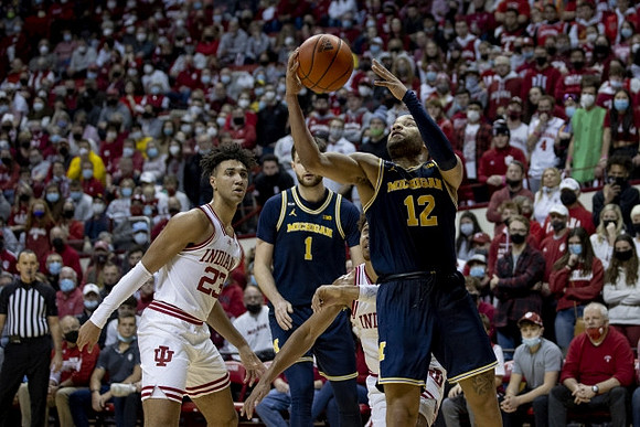 Hunter Dickinson (1) and DeVante' Jones (12)