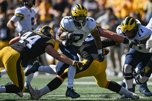 J.J. McCarthy (9), Donovan Edwards (7), and Trevor Keegan (77)