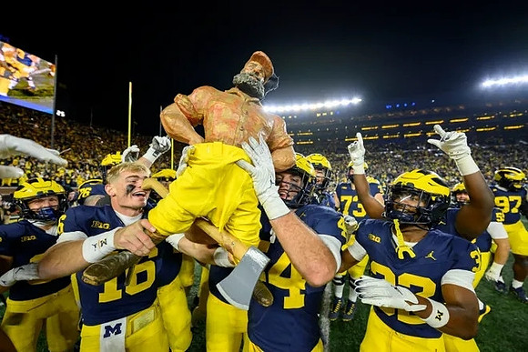 Davis Warren (16), Paul Bunyan Trophy, and Michigan Team