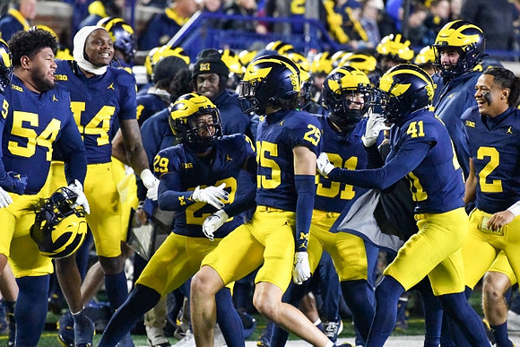 Mason Curtis (25) and Michigan Team