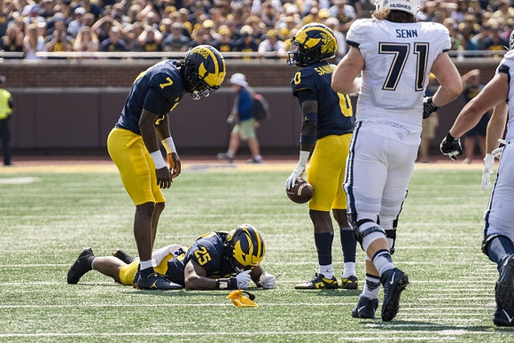 Makari Paige (7), Junior Colson (25), and Mike Sainristil (0)