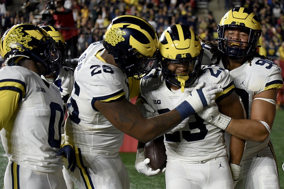Mike Sainristil (0), Rayshaun Benny (26), Michael Barrett (23), and Mike Morris (90)