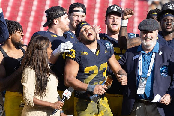 Jordan Marshall (23), Michigan Team, and ReliaQuest Bowl MVP Trophy