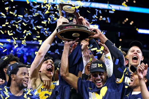 Zavier Simpson (3), Duncan Robinson (22), Muhammad-Ali Abdur-Rahkman (12), Moritz Wagner (13), and West Regional Championship Trophy