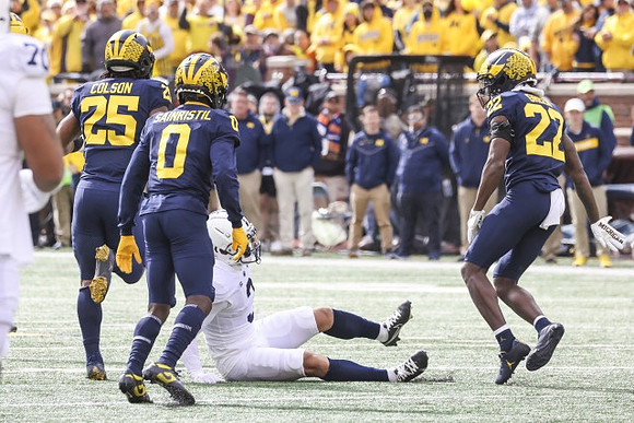 Junior Colson (25), Mike Sainristil (0), and Gemon Green (22)