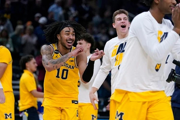 Frankie Collins (10) and Michigan Team