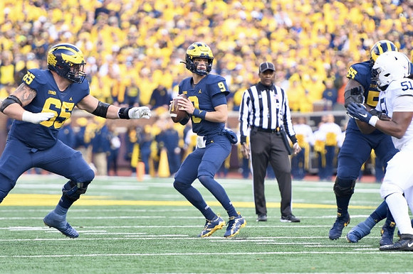 Zak Zinter (65), J.J. McCarthy (9), and Olusegun Oluwatimi (55)
