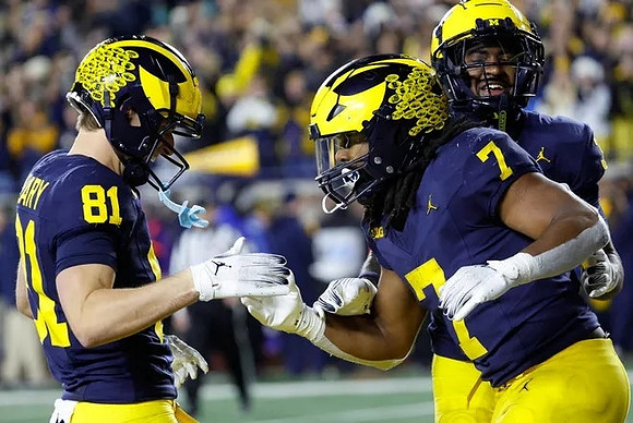 Peyton O'Leary (81) and Donovan Edwards (7)