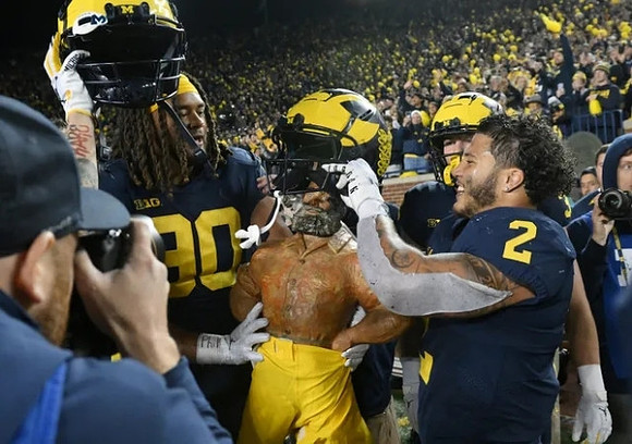 Mike Morris (90), Paul Bunyan Trophy, and Blake Corum (2)