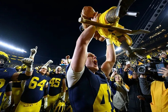 Max Bredeson (44), Paul Bunyan Trophy, and Michigan Team