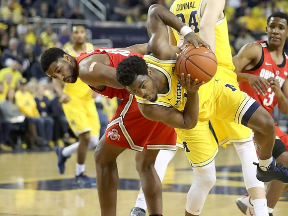 Zak Irvin (21), Derrick Walton Jr. (10), and Mark Donnal (34)