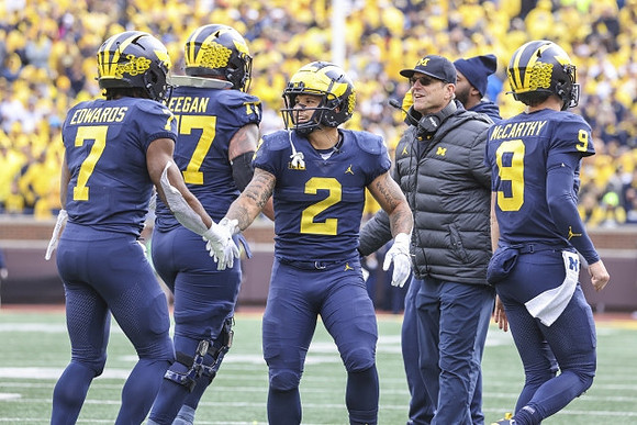 Donovan Edwards (7), Trevor Keegan (77), Blake Corum (2), Jim Harbaugh, and J.J. McCarthy (9)