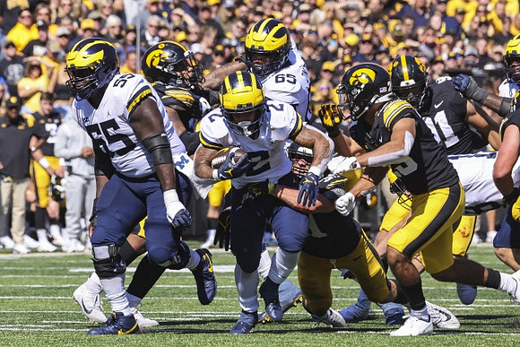 Olusegun Oluwatimi (55), Zak Zinter (65), and Blake Corum (2)