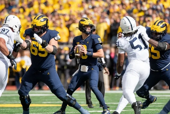 Zak Zinter (65), J.J. McCarthy (9), and Olusegun Oluwatimi (55)