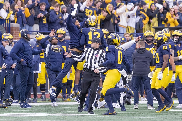 Aamir Hall (12), Josaiah Stewart (0), and Michigan Team
