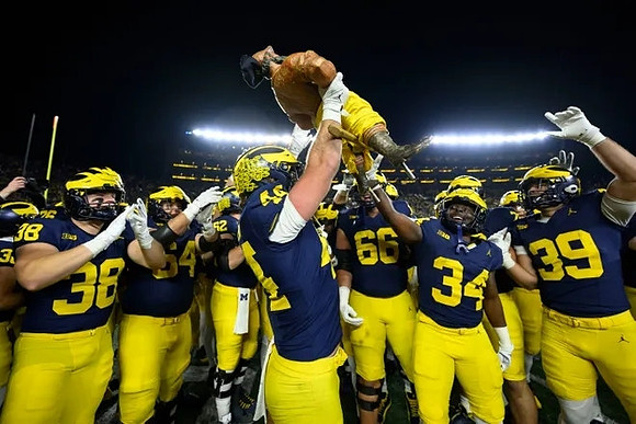 Max Bredeson (44), Paul Bunyan Trophy, and Michigan Team