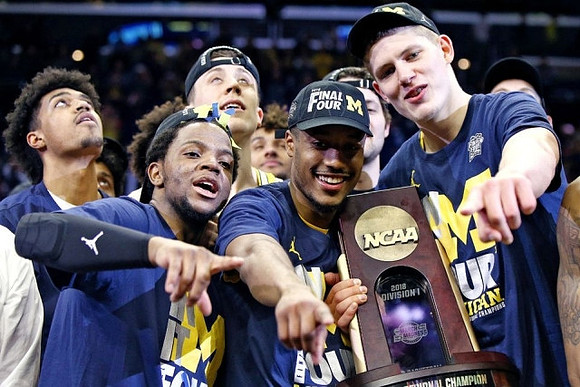 Ibi Watson (23), Zavier Simpson (3), Duncan Robinson (22), Muhammad-Ali Abdur-Rahkman (12), Moritz Wagner (13), and West Regional Championship Trophy