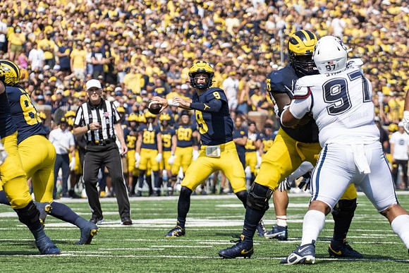 J.J. McCarthy (9) and Olusegun Oluwatimi (55)