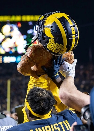 Mike Sainristil (0) and Paul Bunyan Trophy