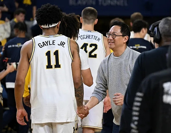 Roddy Gayle Jr. (11), Will Tschetter (42), and UofM President Santa Ono