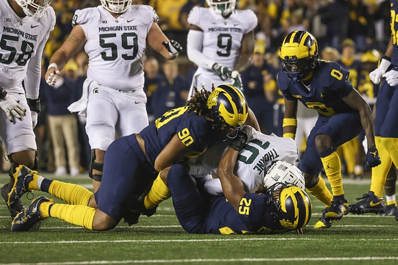 Mike Morris (90), Junior Colson (25), and Mike Sainristil (0)