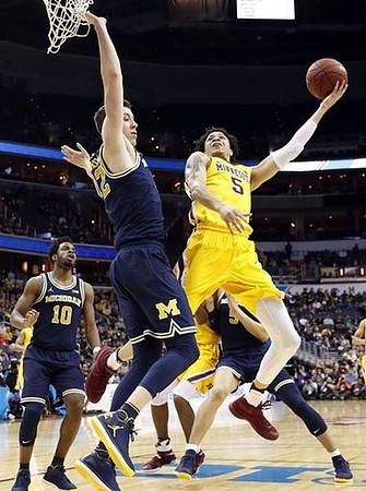 Derrick Walton Jr. (10), Duncan Robinson (22), and D.J. Wilson (5)