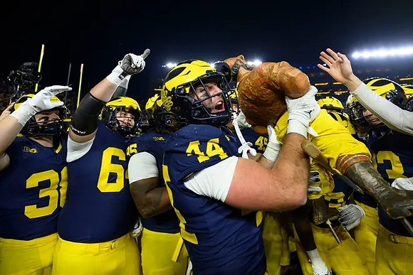 Max Bredeson (44), Paul Bunyan Trophy, and Michigan Team